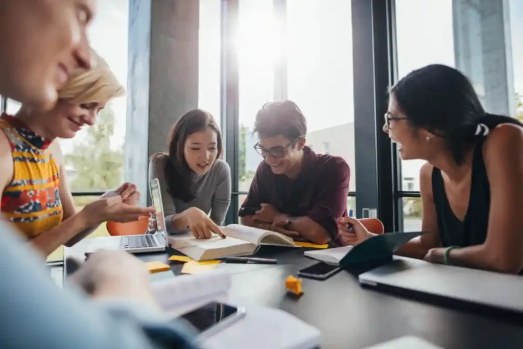 Group of Erasmus students in Malta studying together with books and laptops