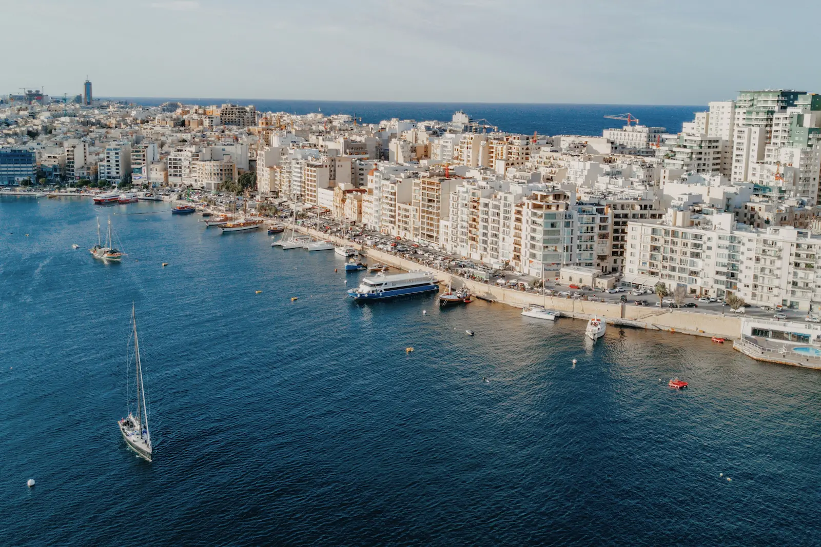 Aerial view of Sliema waterfront with ferries, boats and urban buildings in Malta